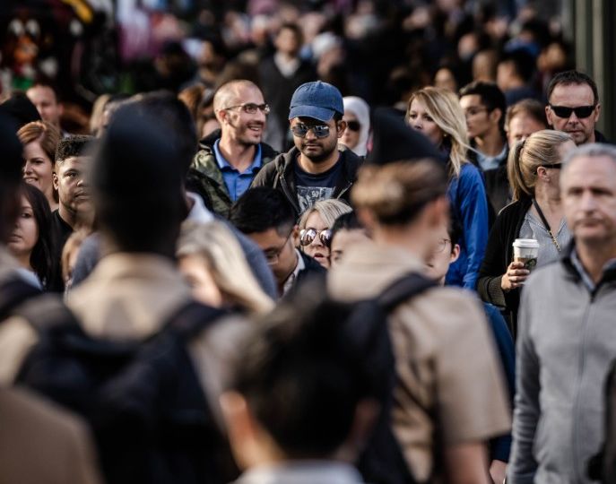 Crowded street of people walking with one person in focus