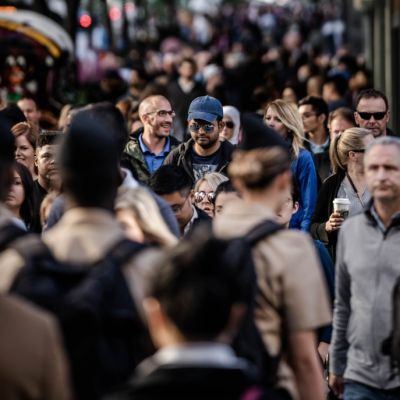 Crowded street of people walking with one person in focus