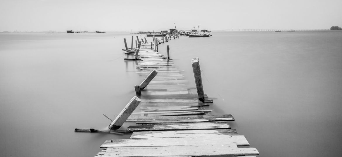 Water overflow on a broken wooden bridge and a hut