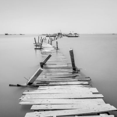 Water overflow on a broken wooden bridge and a hut